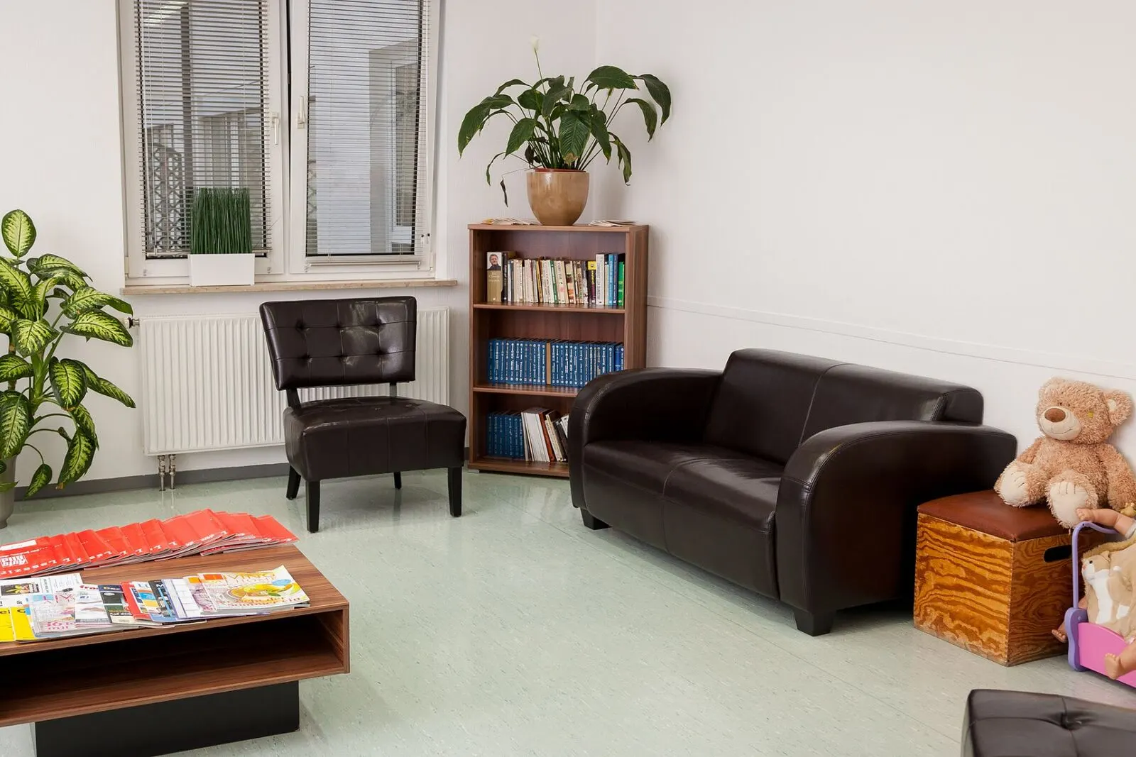 Wartezimmer mit Sofa, Bücherregal und Spielecke für Kinder
