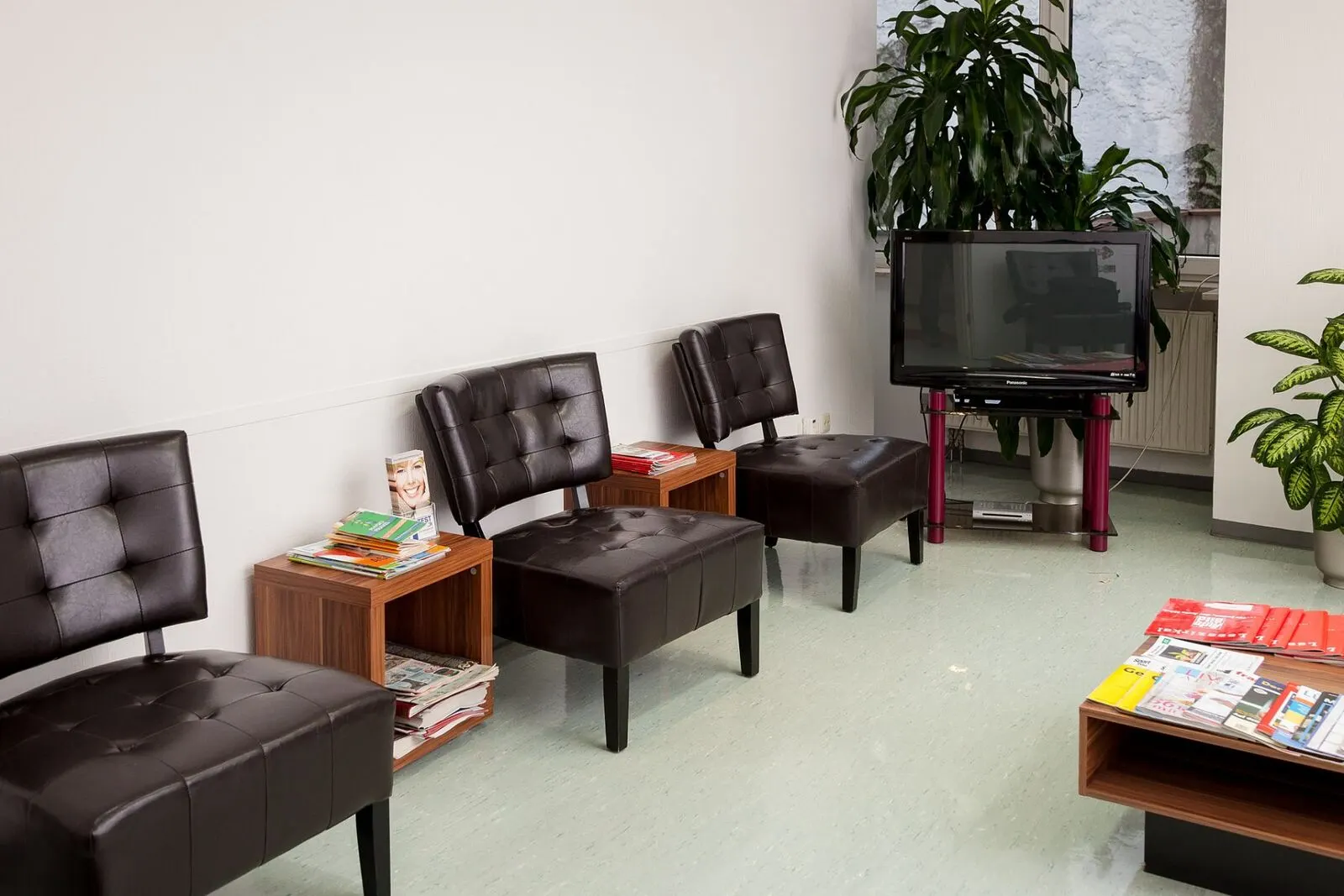 Wartezimmer mit Ledersesseln, Pflanzen und Zeitschriften